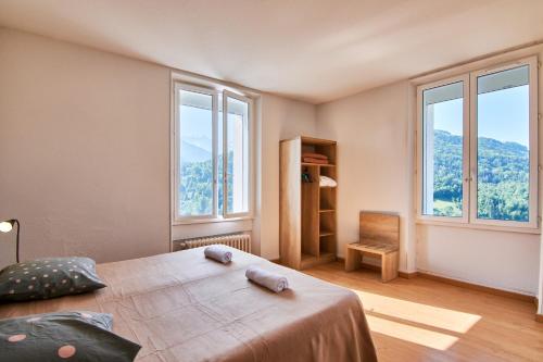 a bedroom with a large bed and two windows at chateau d'escart in Arvillard