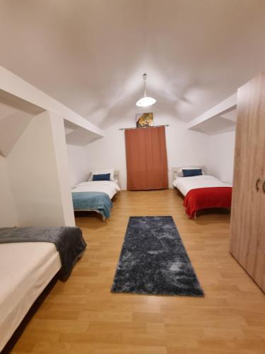 a bedroom with two beds and a rug at Cozy Nest in Salzburg