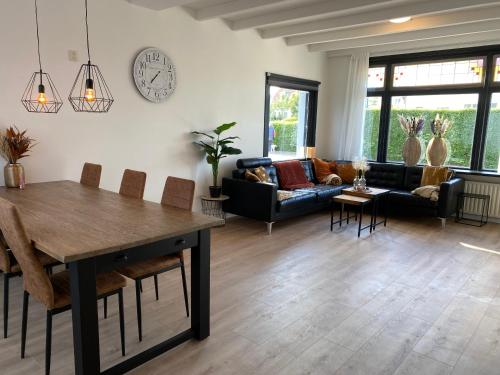 - un salon avec une table et un canapé dans l'établissement The island life beach house 1, à De Koog