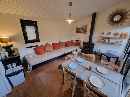 un salon avec un canapé et une table dans l'établissement Charmant cottage dans les pins, entre océan & golf, à Lacanau