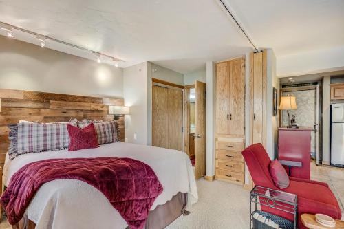 a bedroom with a large bed and a red chair at Laurelwood Condominiums 110 in Snowmass Village