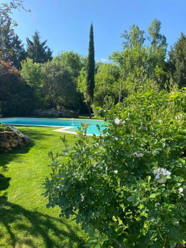 a garden with a swimming pool in the background at Clos Labellie - Gîte et Chambre d'Hôtes à Saint-Emilion in Lugaignac