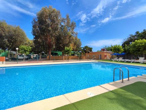 a large swimming pool with blue water at Camping El Jardín in El Campello