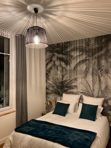 1 dormitorio con 1 cama grande y papel pintado tropical en Le George Sand- hyper centre lumineux, en Tours