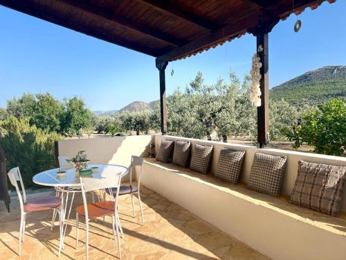 a patio with a table and chairs and a view at Nepis Cottage, GcollectionGr in Ermioni