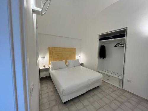 1 dormitorio con 1 cama blanca y nevera en Mana House2 en Maiori