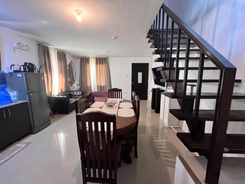 a living room with a dining room table and a staircase at Montierra Subdivision Staycation CDO in Cagayan de Oro