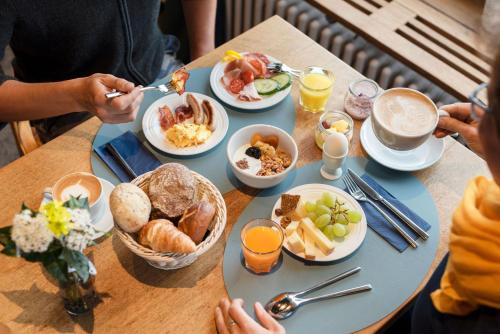 a table topped with plates of breakfast foods at Seehotel Kastanienbaum in Luzern