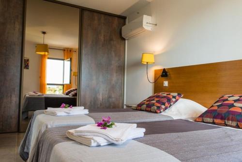 une chambre d'hôtel avec deux lits avec des serviettes dessus dans l'établissement Villa des Arts, 100 meters from the sea, Swimming pool, Wifi, Air conditioning and 6 Bikes, à Sète