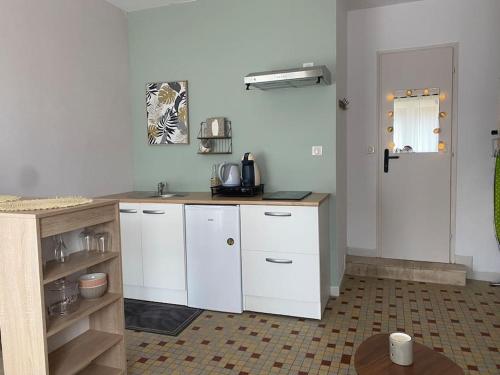 a kitchen with white cabinets and a counter top at L’évidence…. in Flavigny-sur-Moselle