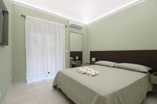 - une chambre avec un grand lit orné de fleurs blanches dans l'établissement Alessia Holiday House 90mq Salerno Centro, à Salerne
