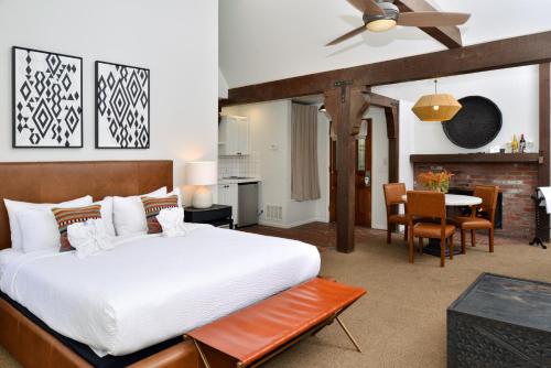 a bedroom with a large bed and a dining room at Wine Valley Inn in Solvang