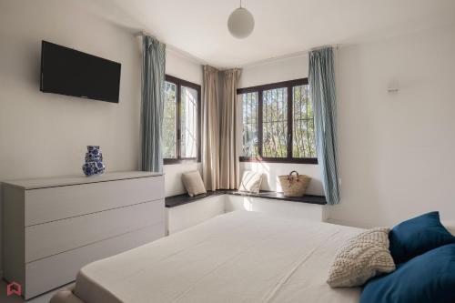 1 dormitorio con 1 cama, TV y ventanas en Stunning seaview villa, en Altavilla Milicia