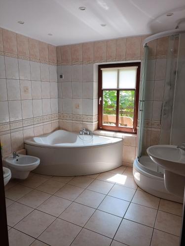 a large bathroom with a tub and two sinks and a tub at Dar Lasu in Narty