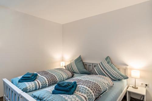 1 dormitorio con 2 camas con sábanas y almohadas azules en Ferienwohnung Eulennest en Schramberg