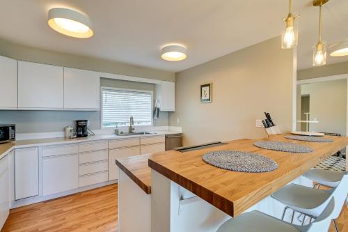 a kitchen with a wooden table and white cabinets at Moclips Home with Hot Tub and Stunning Beach Views! in Moclips