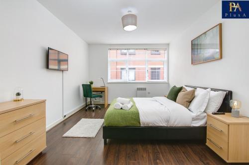 een slaapkamer met een bed, een bureau en een raam bij Pluxa Green Velvet - City Center's Lavish Walk To Transit in Birmingham