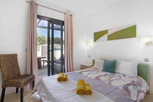 een slaapkamer met een bed met gele schoenen erop bij Recanto Dourado in Porto Santo