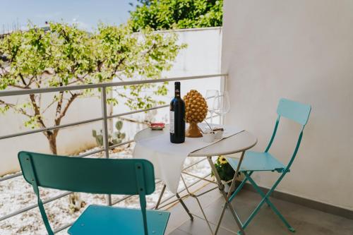 a table with a bottle of wine and two chairs at Villa Sece - Luxury Rooms in Agrigento