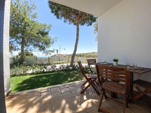 d'une terrasse avec une table et des chaises et une vue sur la cour. dans l'établissement Teach Mhaire apartamento de vacaciones, à Manilva