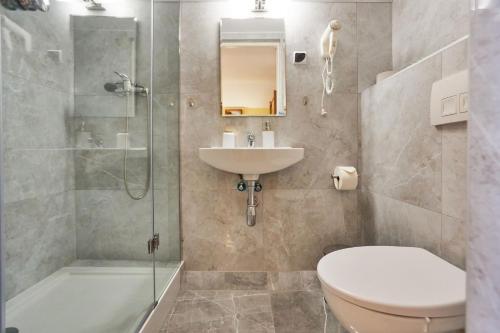 a bathroom with a toilet and a sink and a shower at Villa Eldorado in Rewal