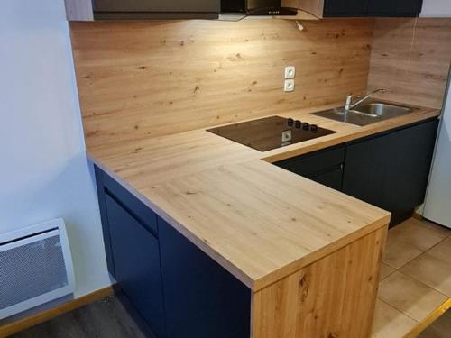 une cuisine avec un comptoir en bois et un évier dans l'établissement Appartement lumineux 2 pièces cabine pour 6 personnes avec balcon à Merlette, Orcières - FR-1-636-96, à Orcières