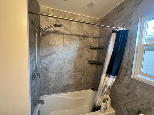 a bathroom with a shower and a tub at Spacious room with TV, Wi-Fi, Netflix, Parking in Edmonton