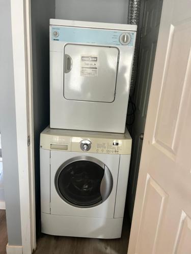 een wasmachine en droger in een kleine kamer bij Spacious room with TV, Wi-Fi, Netflix, Parking in Edmonton