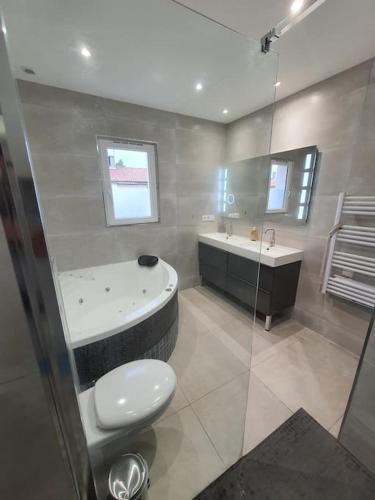 une salle de bain avec une baignoire, des toilettes et un lavabo dans l'établissement Confort et Style Maison Cosy 3 Chambres Narbonne, à Narbonne