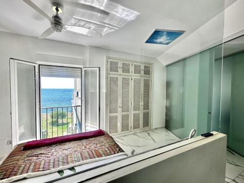 1 dormitorio con cama y ventana grande en Beachfront apartment with pleasant views of the sea and the historic lighthouse., en Mijas Costa