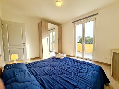 a bedroom with a blue bed and a large window at Santa Caterina in Levanto