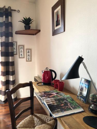 a desk with a lamp and a tea kettle on it at Les Hortensias in Espoey