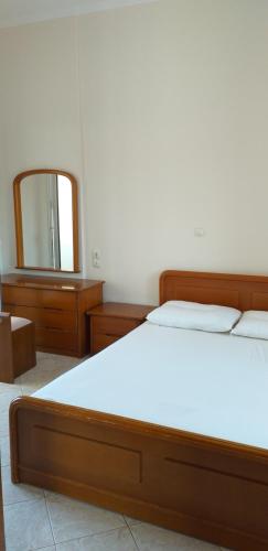 a bedroom with a large bed and a mirror at Toulas House in Elíka
