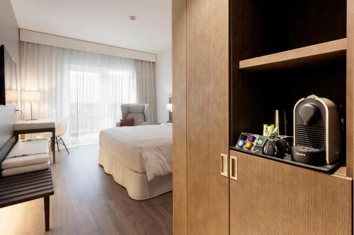 a hotel room with a bed and a desk at AC Hotel by Marriott Paris Le Bourget Airport in Le Bourget