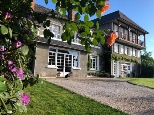 a large house with white windows and a driveway at Les Hortensias in Espoey