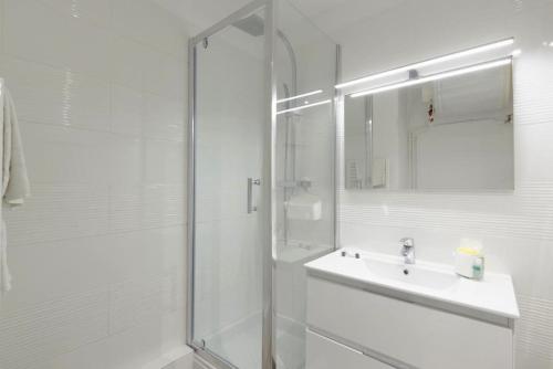 a white bathroom with a shower and a sink at Studio Cosy Aigues Marines in Saint-Cyr-sur-Mer