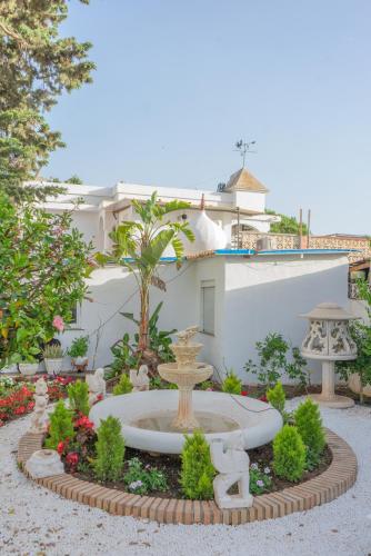 a garden with a fountain in front of a building at Rancho Grande in Marbella