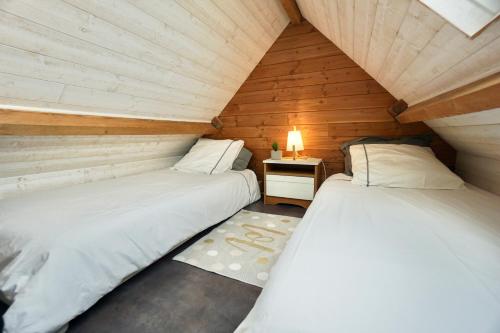 2 camas en un ático con una lámpara en una mesa en Sweet Inn * plage à 200m *, en Ploemeur