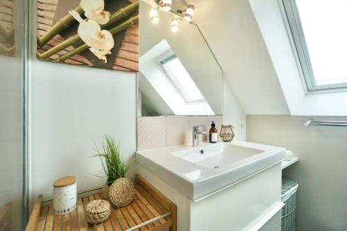une salle de bain avec un lavabo et un miroir dans l'établissement Sweet Inn * plage à 200m *, à Ploemeur