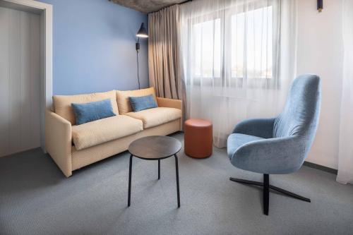 a living room with a couch and a chair and a table at Boutique Hotel Mezi švy in Hradec Králové