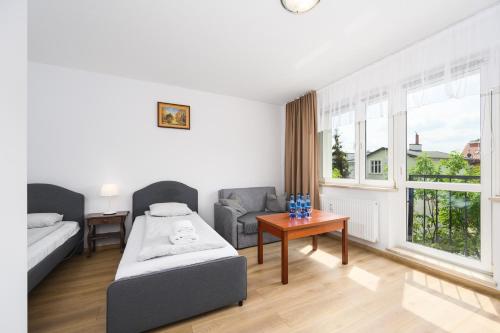 Sala de estar con cama y mesa en Silver by OneApartments, en Sopot