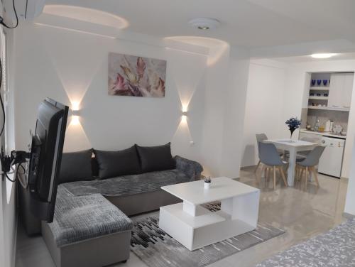 a living room with a couch and a tv and a table at Bibi apartments in Ohrid