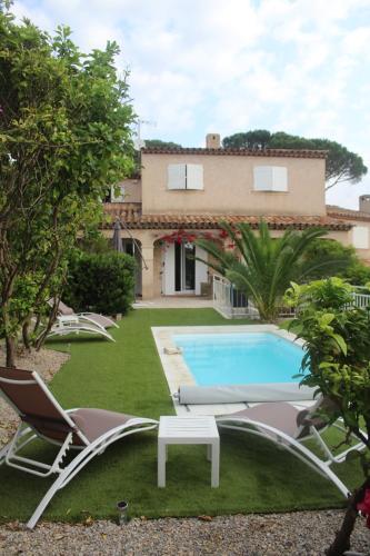 een tuin met stoelen en een zwembad en een huis bij VILLA AUGUSTINA in Sainte-Maxime