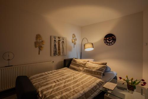 a bedroom with a bed and a table with a lamp at Apartmani "A View to the Danube" in Vukovar