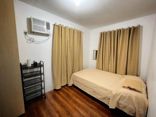 1 dormitorio con 1 cama y aire acondicionado en Montierra Subdivision Staycation CDO en Cagayán de Oro