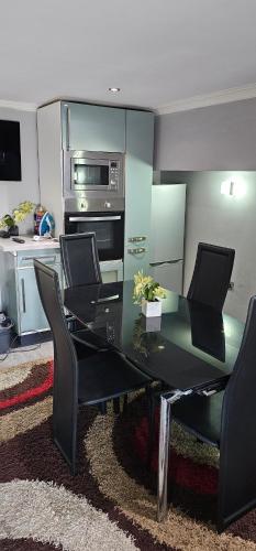 a dining room table with chairs and a kitchen at Oxford Road Apartment in Reading