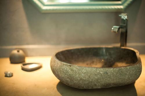 La salle de bains est pourvue d'un lavabo en pierre sur un comptoir. dans l'établissement COHCO'ART GITES, à Fatouville-Grestain