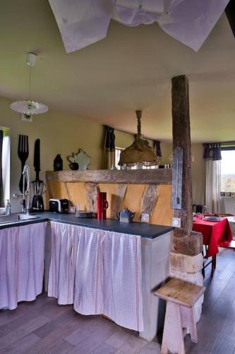 une cuisine avec une table recouverte d'une nappe dans l'établissement COHCO'ART GITES, à Fatouville-Grestain