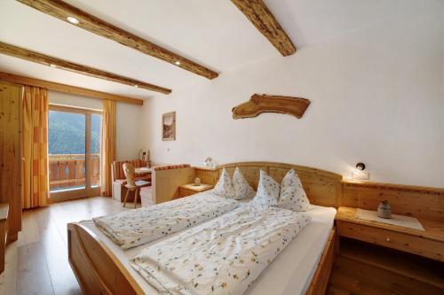 a bedroom with a large bed and a large window at Oberhof Apt Ilmenspitz in Larcher