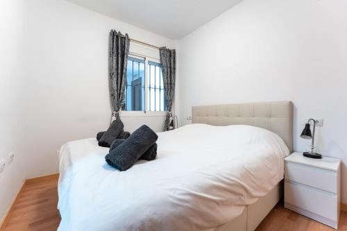 een slaapkamer met een wit bed met 2 kussens erop bij Apartamento Postal in Fuengirola